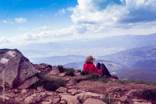 woman sits and looking afar to mountains