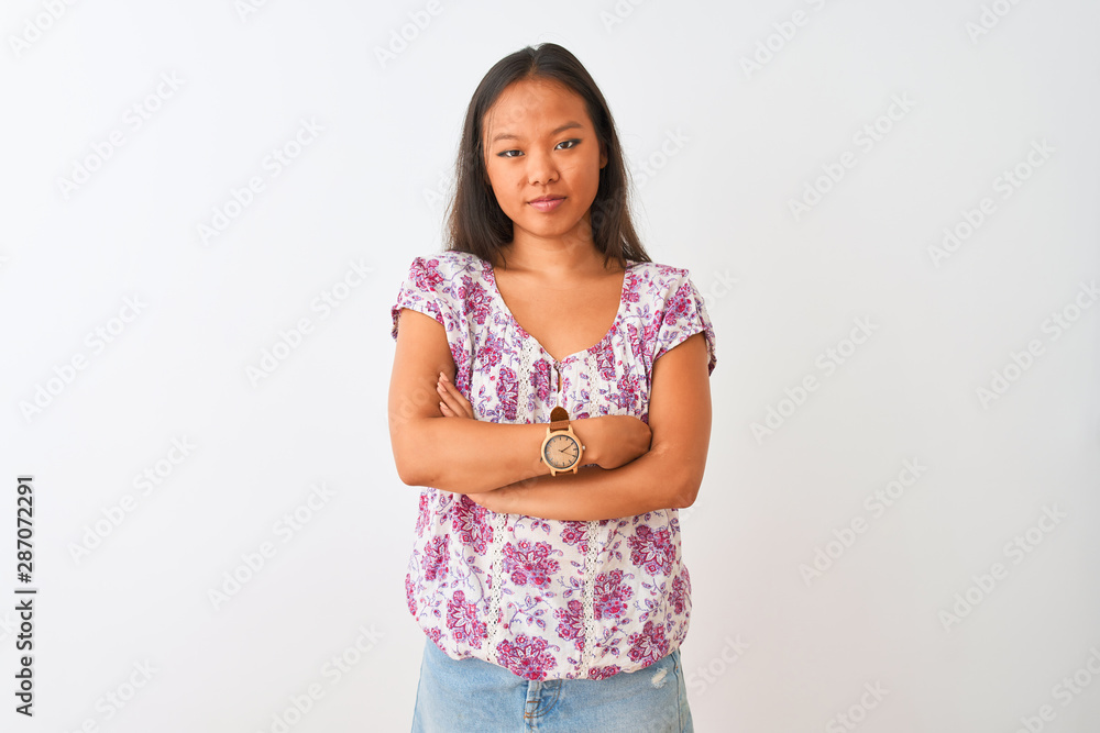 Young chinese woman wearing casual floral t-shirt standing over isolated white background skeptic and nervous, disapproving expression on face with crossed arms. Negative person. Young chinese woman wearing casual floral t-shirt standing over isolated white background skeptic and nervous, disapproving expression on face with crossed arms. Negative person.