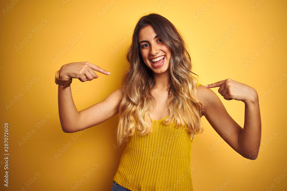 Young beautiful woman wearing t-shirt over yellow isolated background looking confident with smile on face, pointing oneself with fingers proud and happy. Young beautiful woman wearing t-shirt over yellow isolated background looking confident with smile on face, pointing oneself with fingers proud and happy.