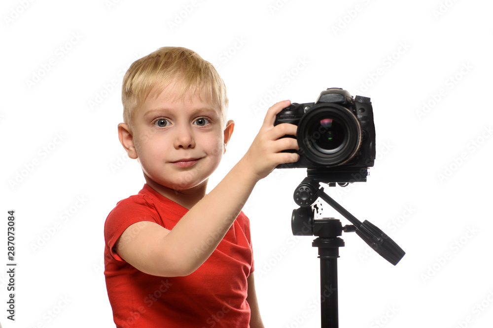Blond boy shoots video on DSLR camera. Front view. White background, isolate