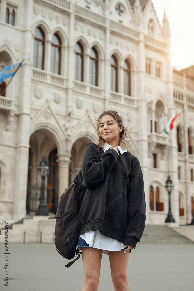 Casual woman student enjoying great view of the Parliament building in Budapest city, travel in Europe concept
