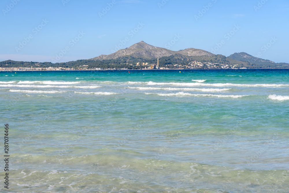 Shallow and turquoise waters of the bay of Alcudia in north part of Mallorca. Spain