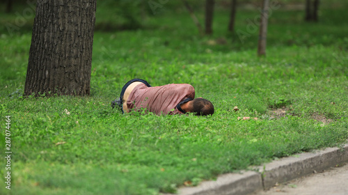 drunk homeless man sleeping on the lawn