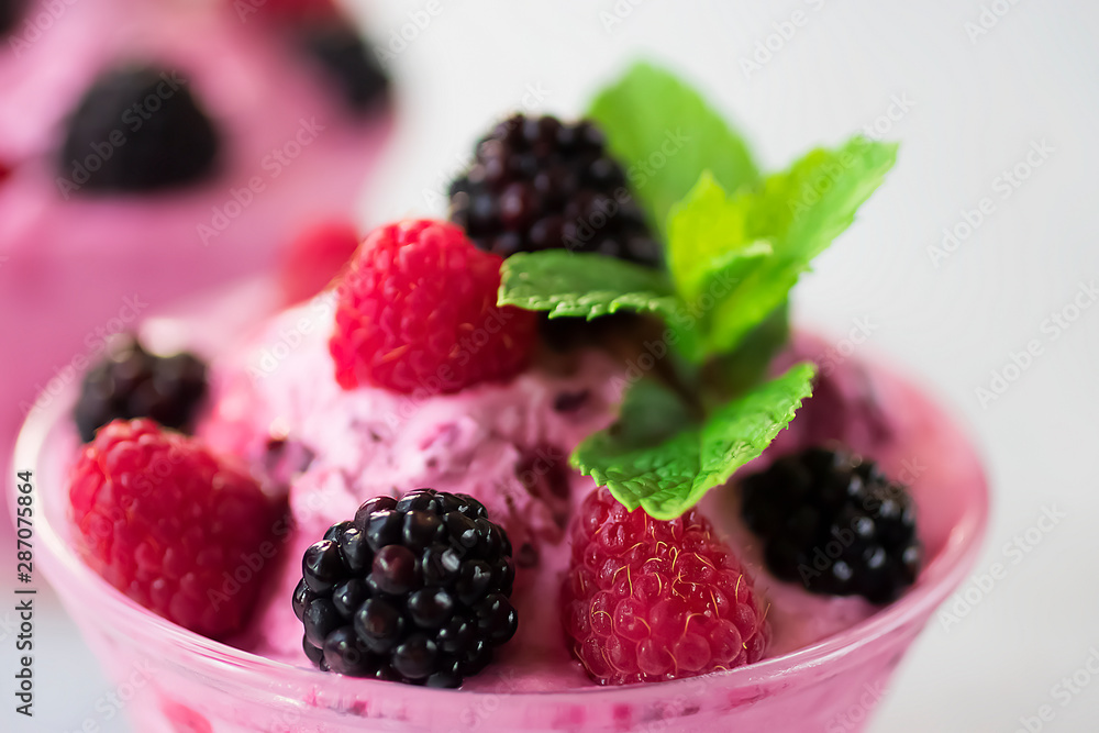 Homemade sorbet made from fresh berries with mint in glass bowl on a gray background. Homemade sorbet made from fresh berries with mint in glass bowl on a gray background.