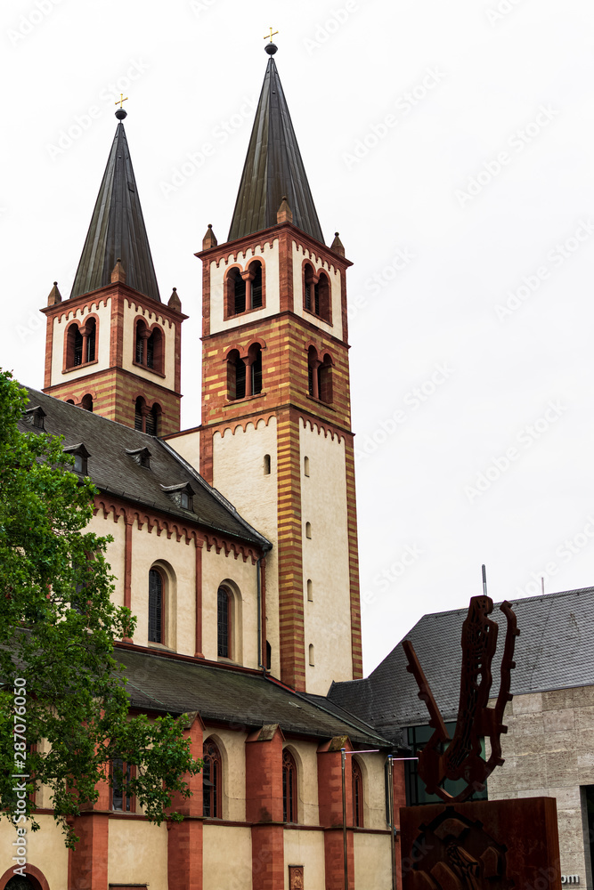 Vertical view of the Würzburg Cathedral along with the art of a metal sculpture, photograph taken in Würzburg, Germany. Vertical view of the Würzburg Cathedral along with the art of a metal sculpture, photograph taken in Würzburg, Germany.