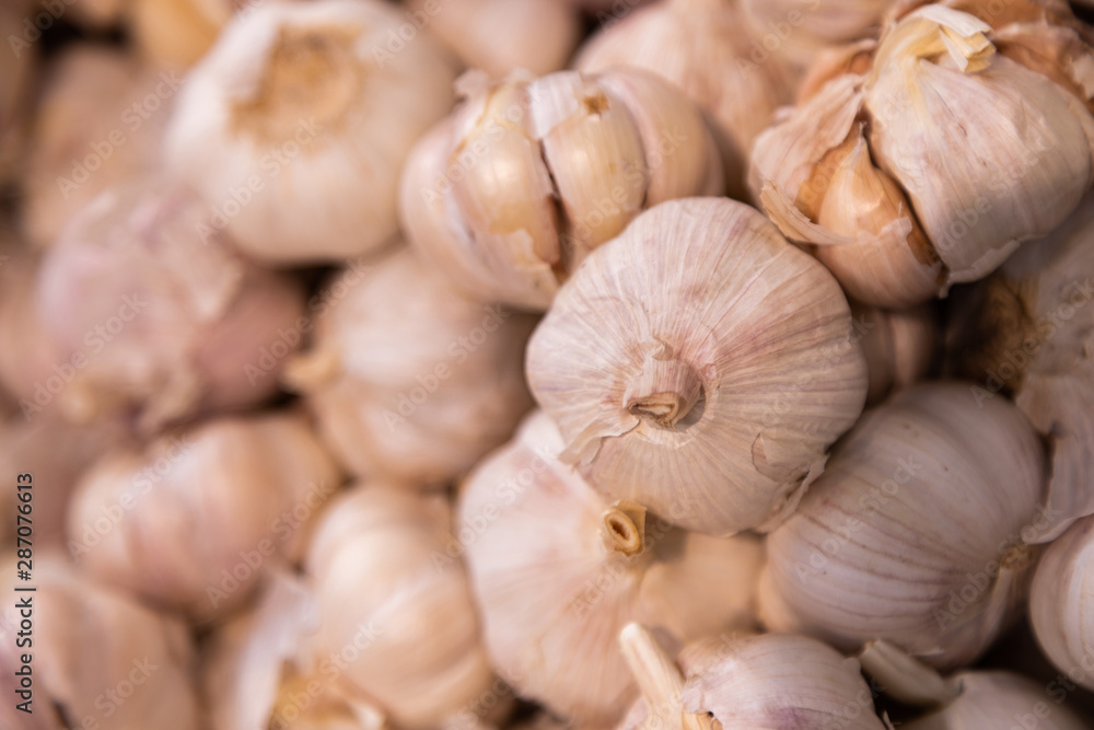 Pile of white garlic heads close-up. Garlic texture, meat dish ingredient. Pile of white garlic heads close-up. Garlic texture, meat dish ingredient.
