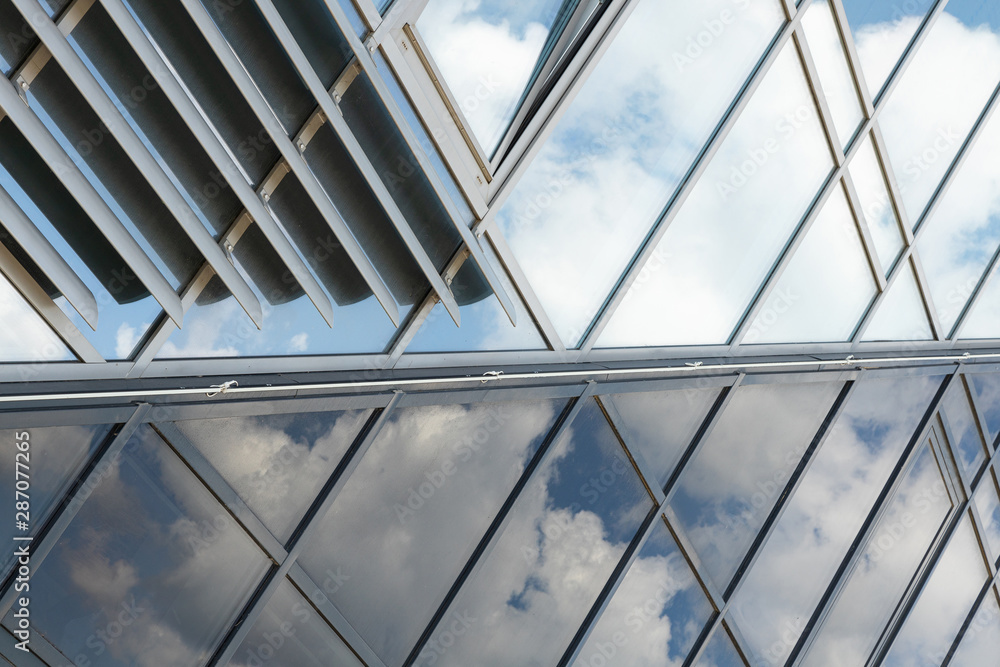 shiny glass wall with darkening glass and sheer glass joint with sky reflection, mirrorlike shiny glass wall with darkening glass and sheer glass joint with sky reflection, mirrorlike