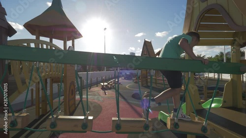 Wallpaper Mural A boy crossing a bridge and sliding at a big playground Torontodigital.ca