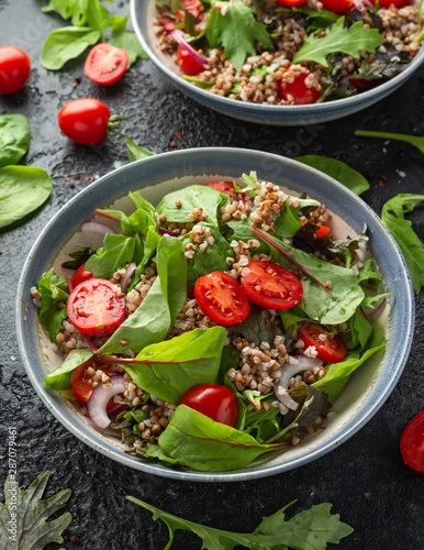 Buckwheat salad with cherry tomatoes, red onion and green vegetables. Healthy diet food