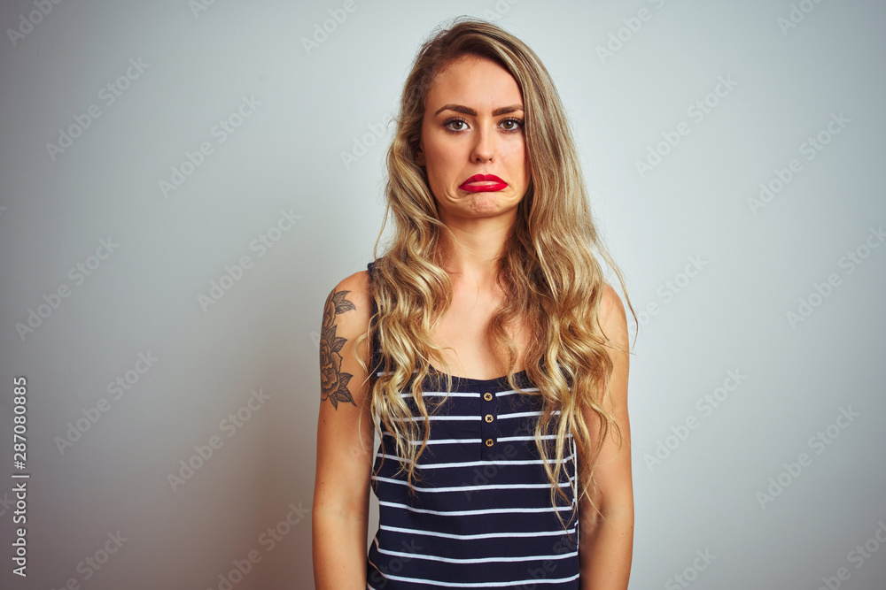 Young beautiful woman wearing stripes t-shirt standing over white isolated background depressed and worry for distress, crying angry and afraid. Sad expression. Young beautiful woman wearing stripes t-shirt standing over white isolated background depressed and worry for distress, crying angry and afraid. Sad expression.