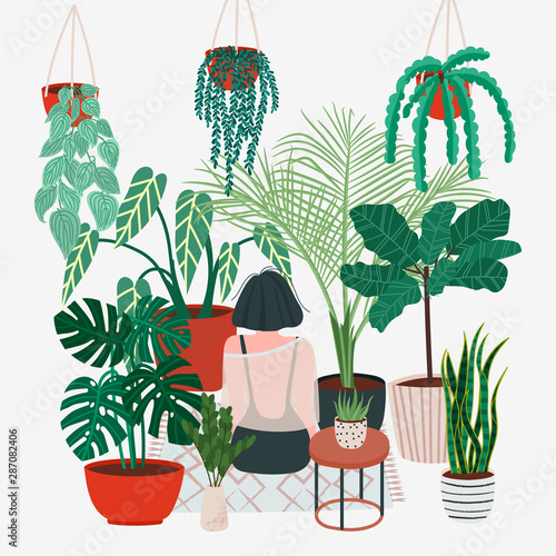 Girl caring for plants. Greenhouse, plants growing in pots. 