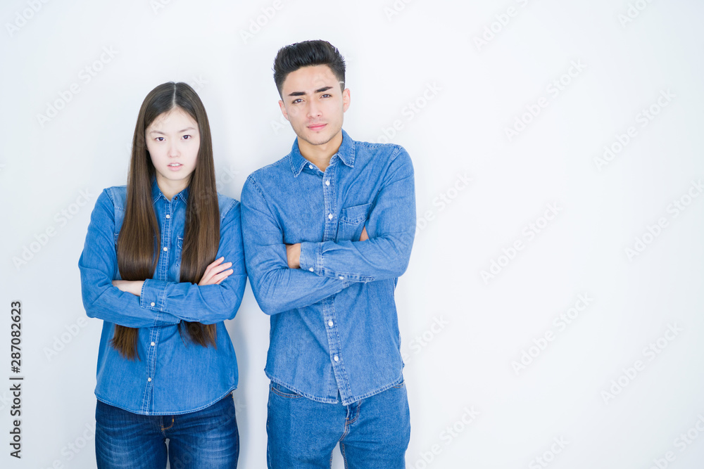 Beautiful young asian couple over white isolated background skeptic and nervous, disapproving expression on face with crossed arms. Negative person. Beautiful young asian couple over white isolated background skeptic and nervous, disapproving expression on face with crossed arms. Negative person.