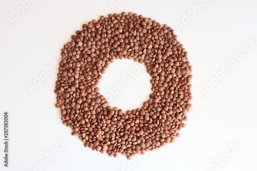 Brown lentils isolated close-up on a white background in the form of a circle