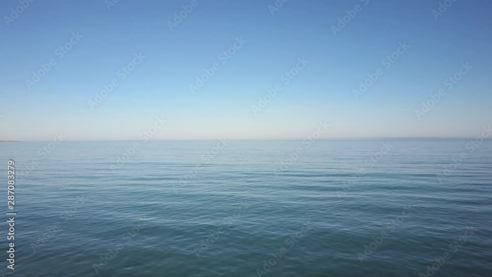 Aerial view of drone flight above calm and tranquil turquoise ocean water, smooth shimmering surface as backdrop or wallpaper. Aerial view of drone flight above calm and tranquil turquoise ocean water, smooth shimmering surface as backdrop or wallpaper.