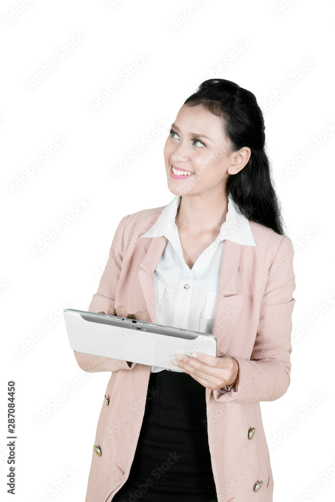 Pensive female entrepreneur uses a tablet on studio Pensive female entrepreneur uses a tablet on studio