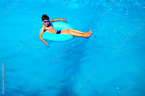 top view boy in the pool on an rubber ring, healthy lifestyle concept.