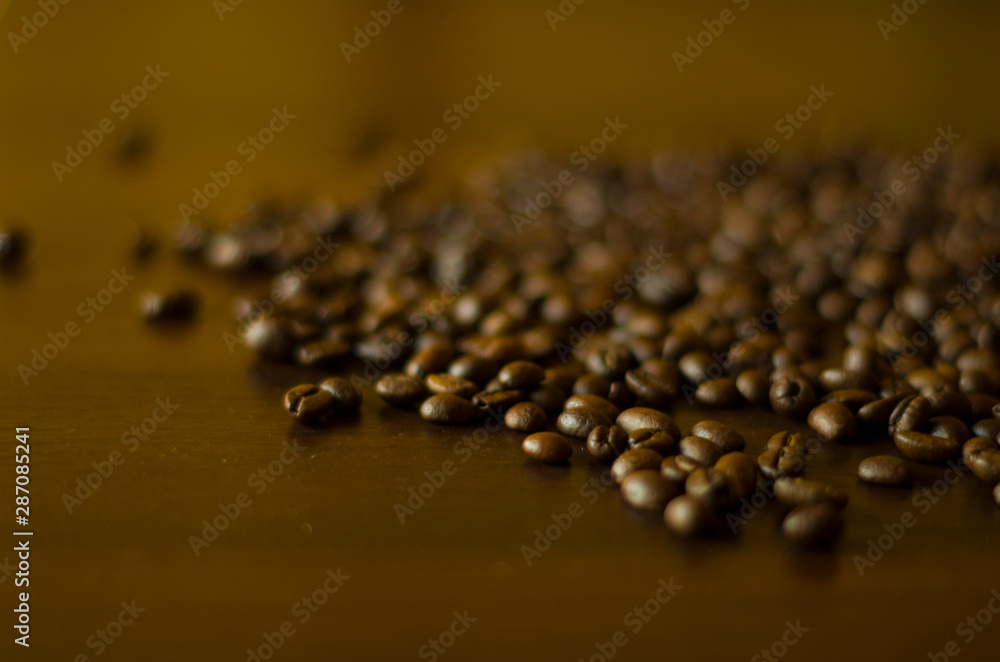 Aromatic roasted coffee beans at the brown wooden background Aromatic roasted coffee beans at the brown wooden background