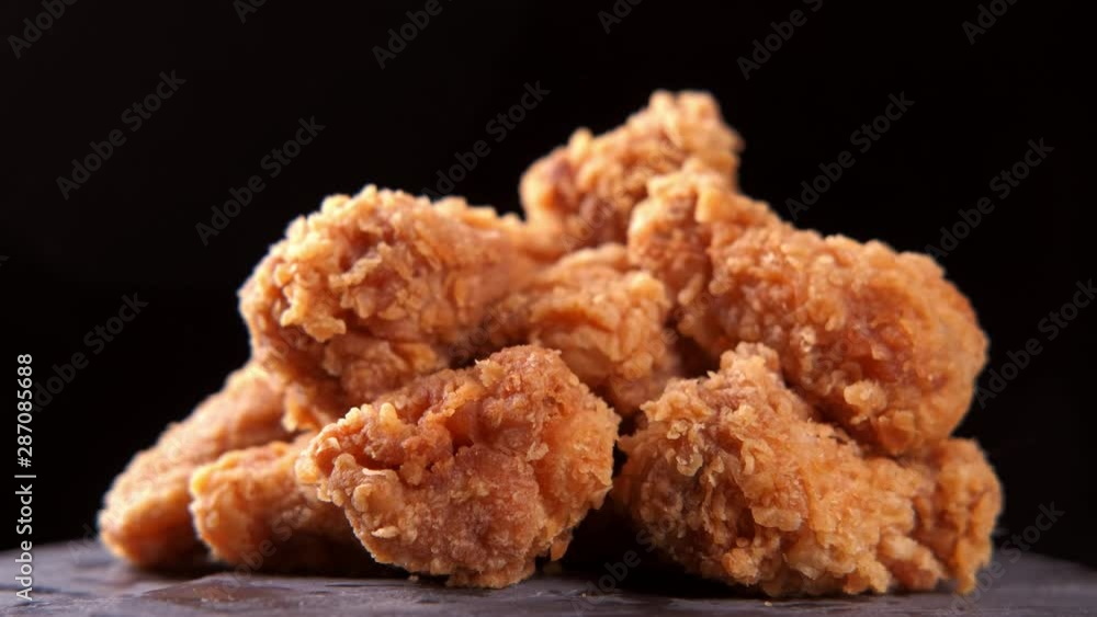 Crispy fried chicken wings and legs with french fries on a wooden table rotation 360 degrees. Breaded Crispy chicken, fried potato tasty dinner. 4K UHD video footage. Ultra high definition 3840X2160 Crispy fried chicken wings and legs with french fries on a wooden table rotation 360 degrees. Breaded Crispy chicken, fried potato tasty dinner. 4K UHD video footage. Ultra high definition 3840X2160