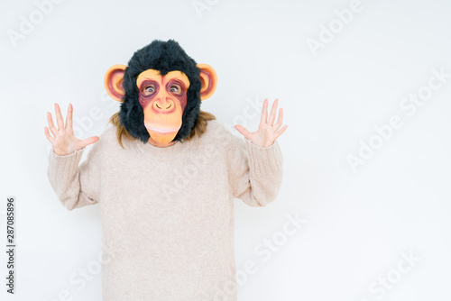 Middle age woman wearing funny and crazy money mask over isolated background scared in shock with a surprise face, afraid and excited with fear expression