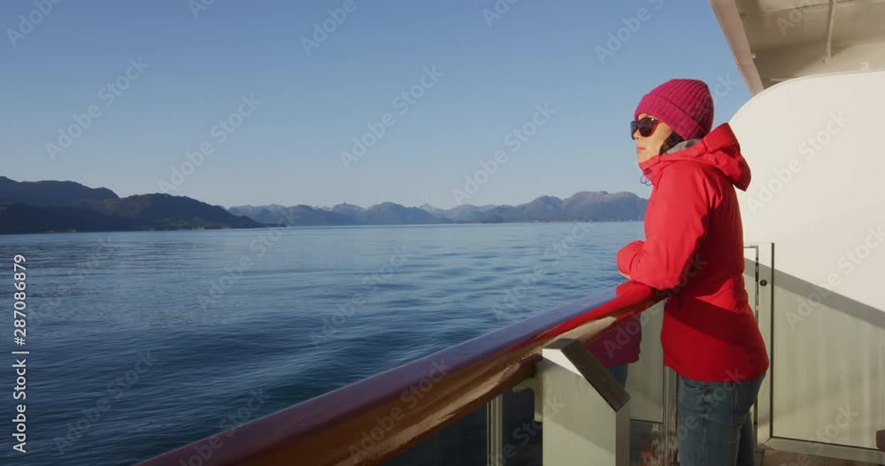 Alaska cruise ship travel tourist woman watching nature landscape from balcony cabin stateroom standing in inside passage, USA. Alaska cruise ship travel tourist woman watching nature landscape from balcony cabin stateroom standing in inside passage, USA.