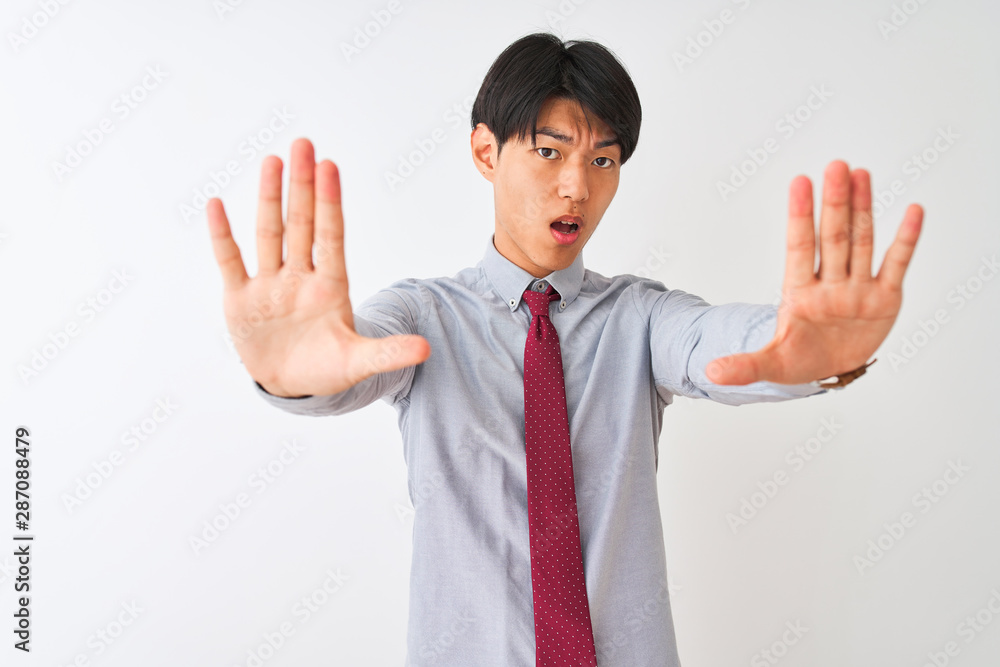 Chinese businessman wearing elegant tie standing over isolated white background doing stop gesture with hands palms, angry and frustration expression Chinese businessman wearing elegant tie standing over isolated white background doing stop gesture with hands palms, angry and frustration expression