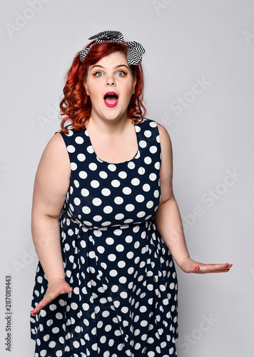 Pin up woman portrait. Beautiful retro female in polka dot dress with red lips and manicure nails and old fshion hairstyle photo