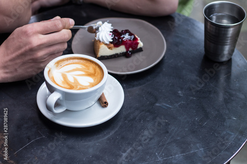 young eating tasty blueberry cheesecake at table.