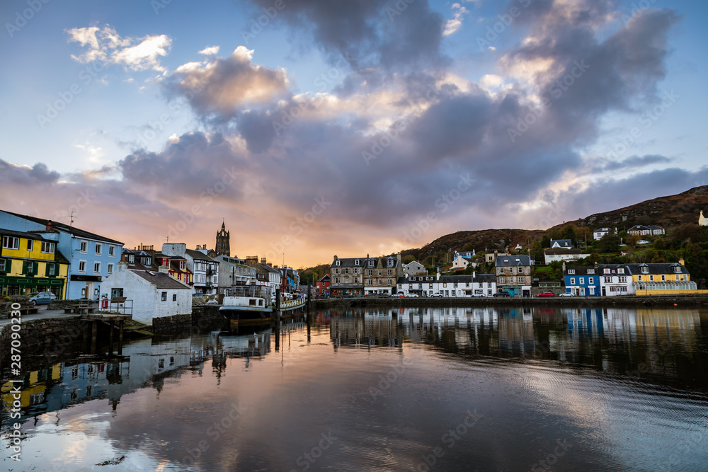 Φωτογραφία Clouds start to turn pink reflecting in the still water of Tarbert Harbour with