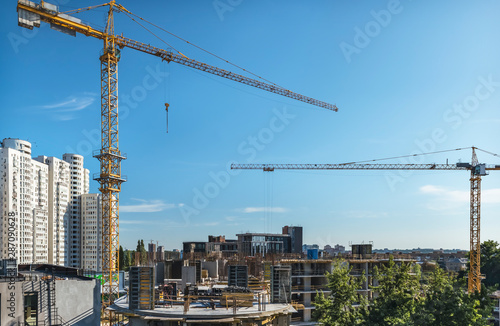 A fragment of the city of Kiev, Ukraine. In the foreground are tower cranes over one of the new buildings, as well as constructed residential and office buildings.
