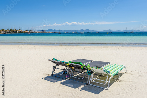 Fototapeta Naklejka Na Ścianę i Meble -  Sunbeds at the Playa de Alcudia beach in Mallorca, Spain