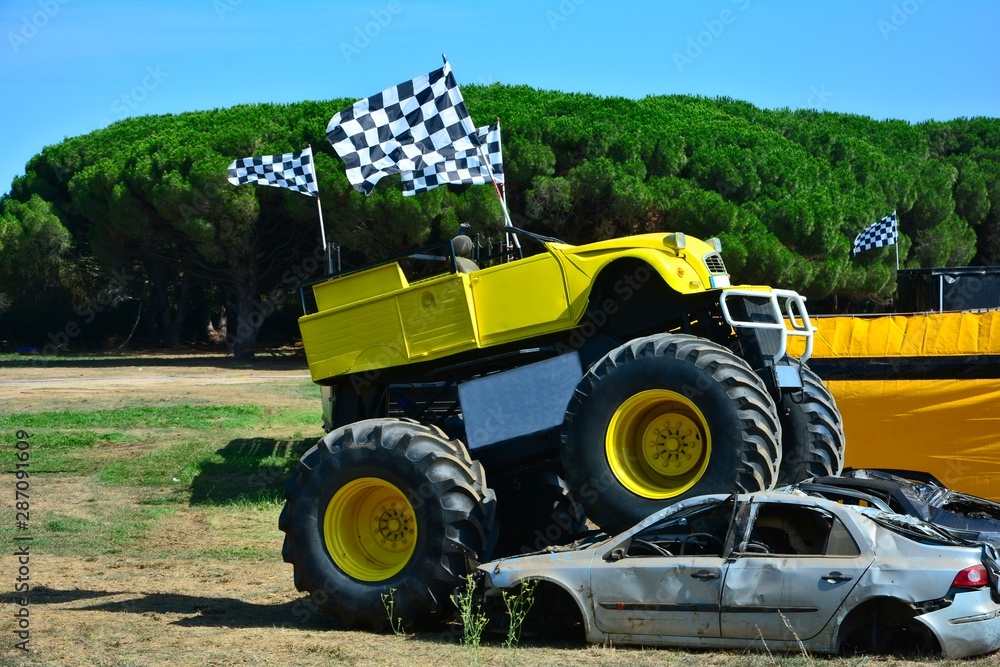 Obraz premium Monster Truck is standing on two crushed cars