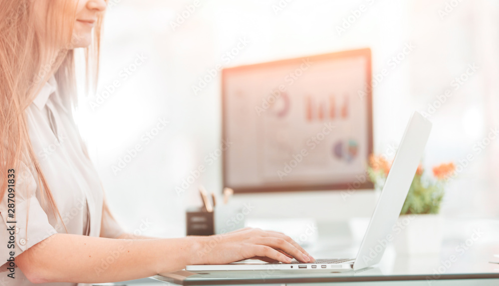Fototapeta premium accountant working on a laptop with financial charts on the desktop.