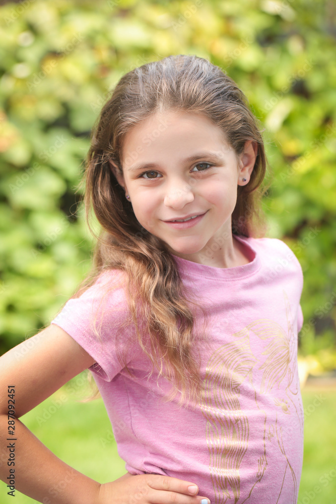 Close up Portrait of 8 Years Old Girl, with Brown Long Hair and Big Brown  Eyes, Happy Child, Green Background Stock Photo