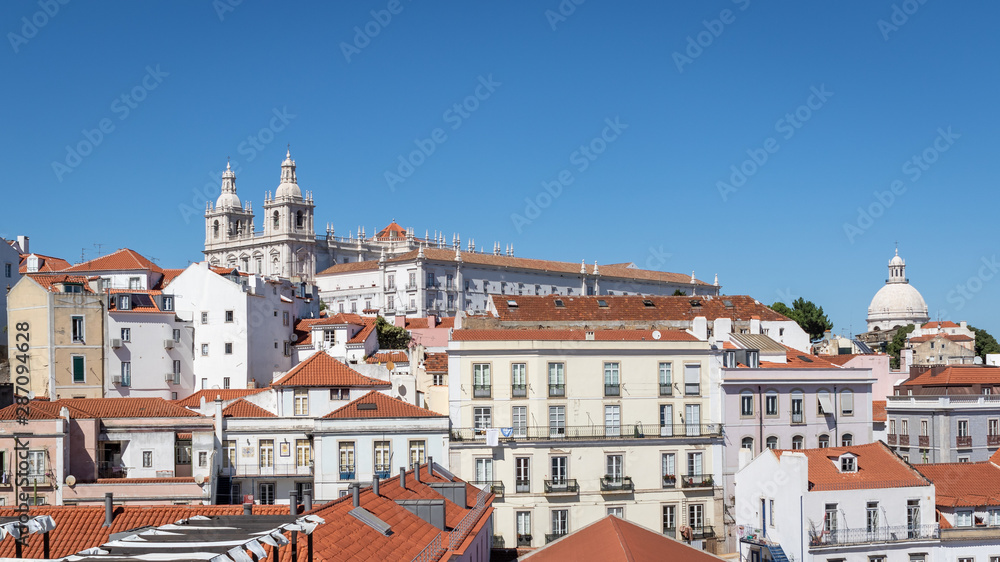 View of historic Alfama district in Lisbon, capital of Portugal on a sunny day. Church and monastery of Sao Vicente of Fora on the top of a hill