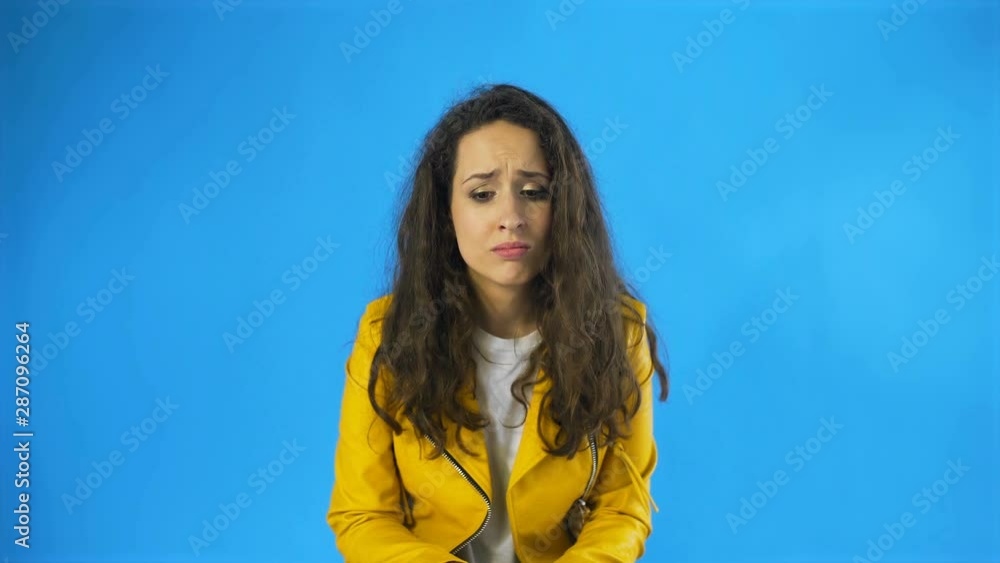 Very sad young woman almost crying in Studio with blue Background. Very sad young woman almost crying in Studio with blue Background.