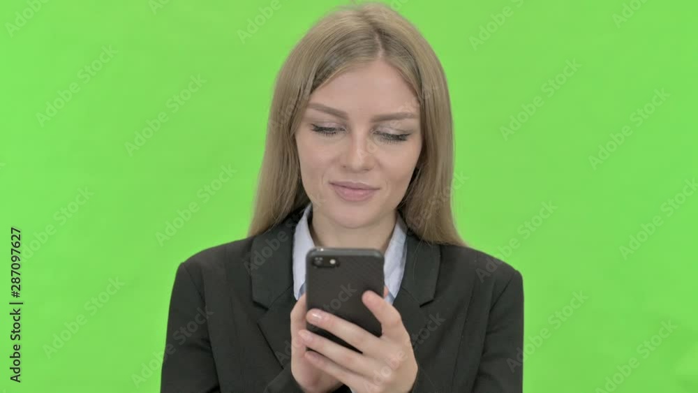 Young Businesswoman Using Smartphone against Chroma Key Young Businesswoman Using Smartphone against Chroma Key