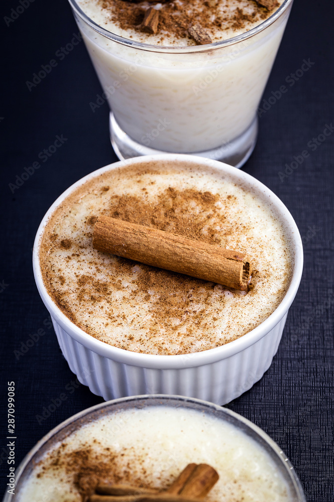 jars of rice pudding with cinnamon. Typical porridge from Brazil made with rice, condensed milk and coconut. Brazilian food typical of rural parties of June and July. Gastronomic tourism concept. jars of rice pudding with cinnamon. Typical porridge from Brazil made with rice, condensed milk and coconut. Brazilian food typical of rural parties of June and July. Gastronomic tourism concept.
