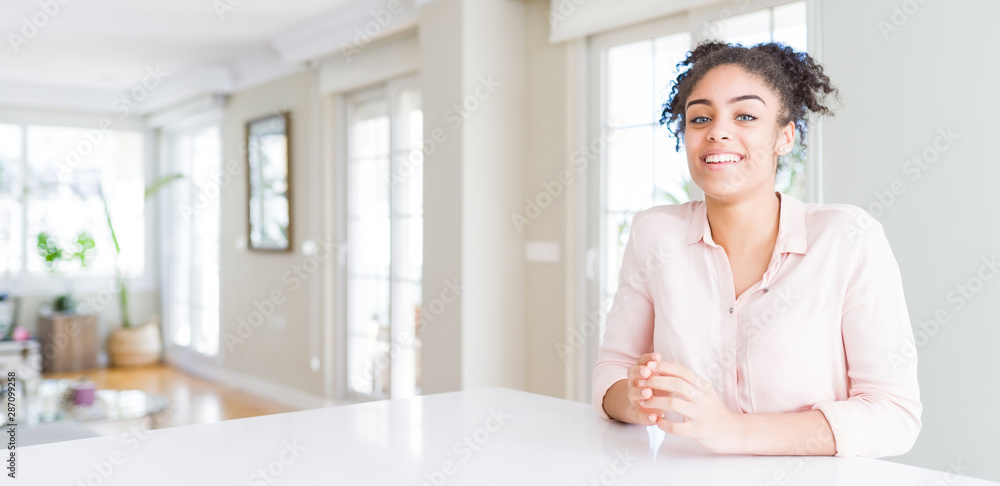 Wide angle of beautiful african american woman with afro hair Hands together and fingers crossed smiling relaxed and cheerful. Success and optimistic