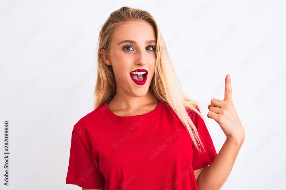 Young beautiful woman wearing red casual t-shirt standing over isolated white background pointing finger up with successful idea. Exited and happy. Number one. Young beautiful woman wearing red casual t-shirt standing over isolated white background pointing finger up with successful idea. Exited and happy. Number one.