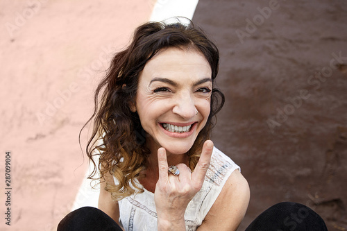 Adult woman gesturing in front of a pinnk and brown wall , San Sebastian photo