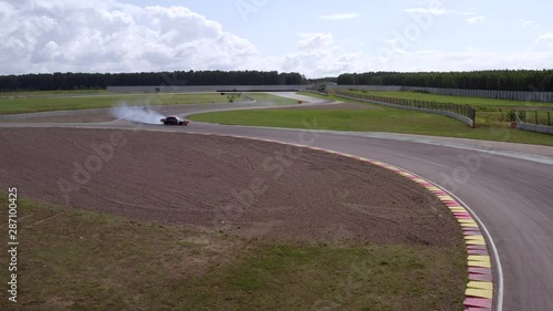 Car drifting on racing track aerial view. Japanese car drifting with smoke from burning tires on speed track. Professional driver drifting car on asphalt track photo