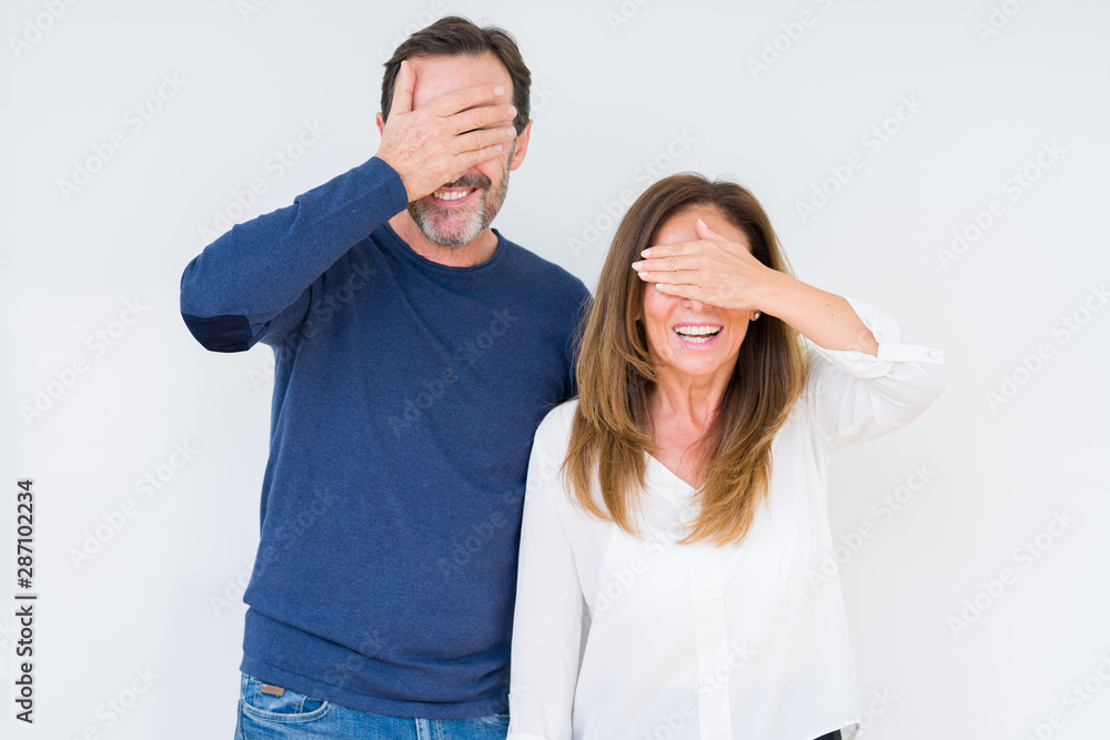 Beautiful middle age couple in love over isolated background smiling and laughing with hand on face covering eyes for surprise. Blind concept. Beautiful middle age couple in love over isolated background smiling and laughing with hand on face covering eyes for surprise. Blind concept.