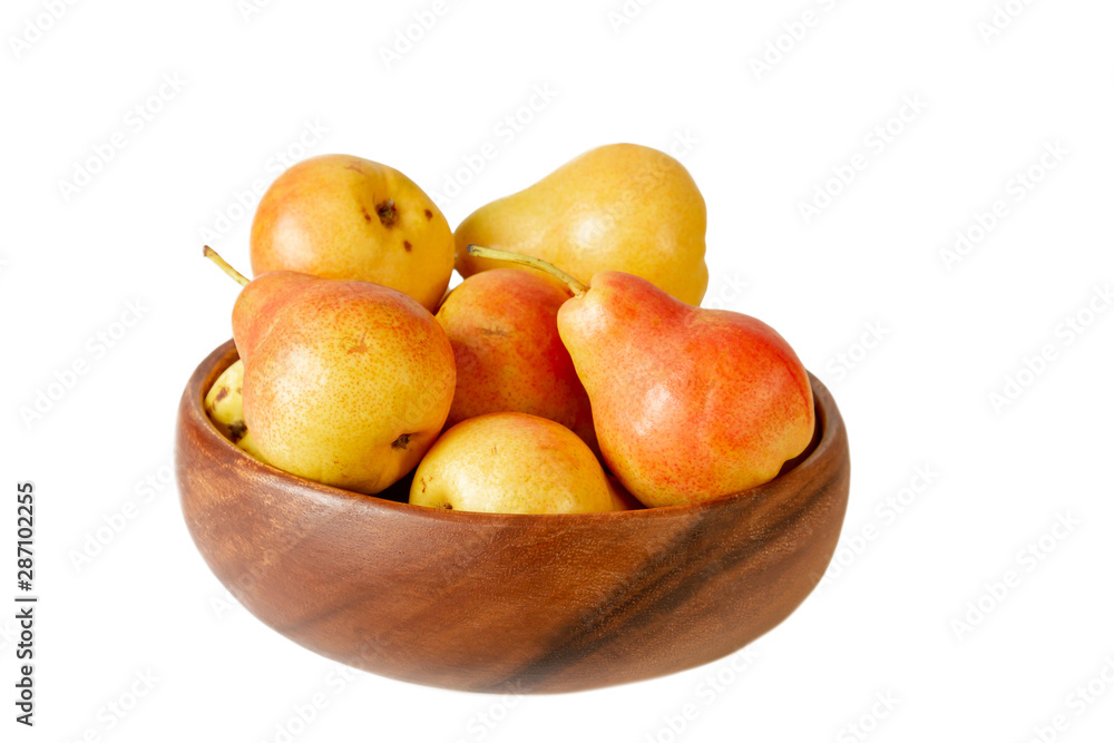 Pear in wooden bowl on white. Organic pear fruits isolated on white background. Pear in wooden bowl on white. Organic pear fruits isolated on white background.
