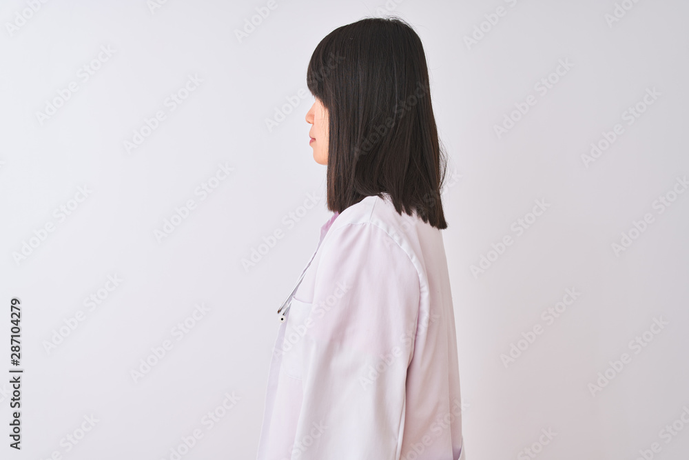 Young beautiful chinese doctor woman wearing stethoscope over isolated white background looking to side, relax profile pose with natural face with confident smile. Young beautiful chinese doctor woman wearing stethoscope over isolated white background looking to side, relax profile pose with natural face with confident smile.
