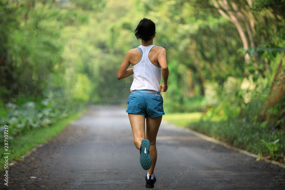 Female runner running at summer park trail . Healthy fitness woman jogging  outdoors. Stock Photo