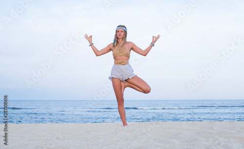 Young woman practicing yoga on the beach. Vrksasana pose © Dmytro Flisak