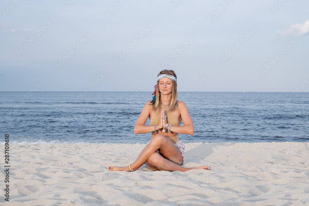 Young woman practicing yoga on the beach in Gomukasana pose Young woman practicing yoga on the beach in Gomukasana pose