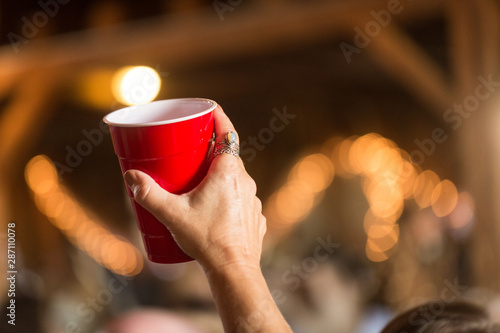 Woman's hand holding up red solo cup in cheer