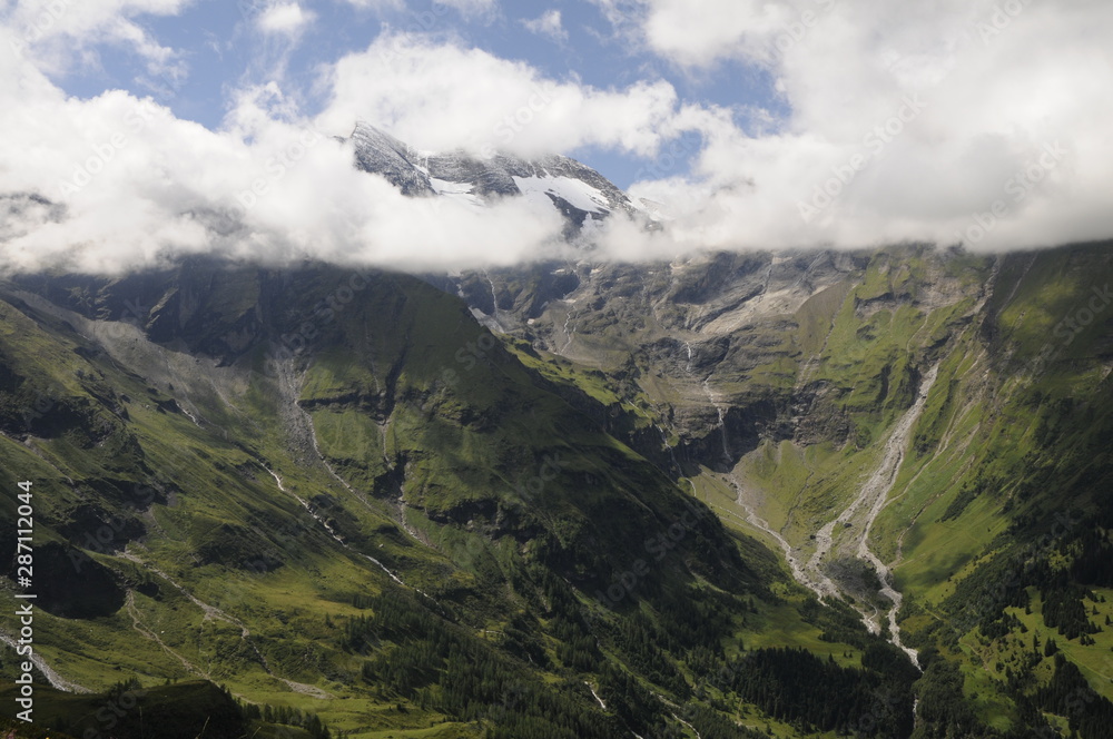 Alpine peak in clouds with snow on top