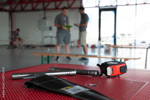 Tools on table and two technicians discussing in background © vasek.x1